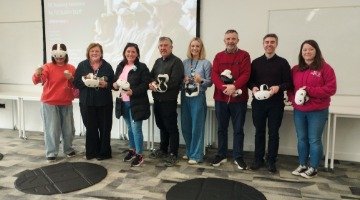 A group of staff holding VR headsets