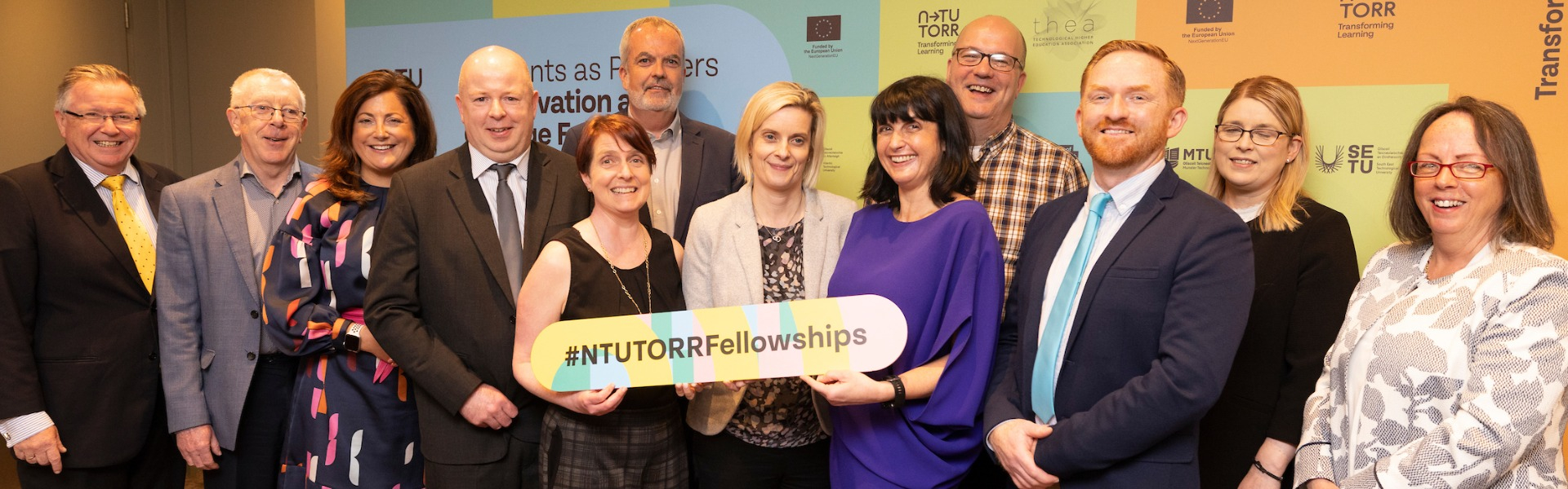 Photo of smiling people holding banner at the N-TUTORR launch event in Dublin