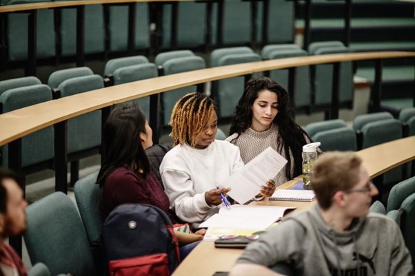 Students studying notes in a lecture theatre