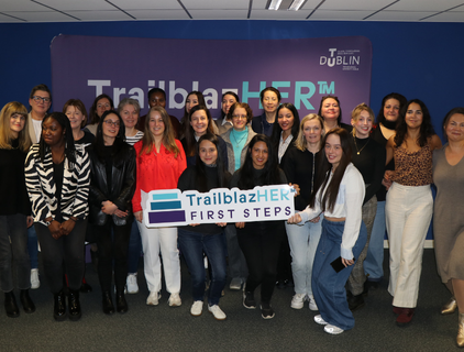 A group of women pose for a photo without a cutout with TrailblazHER First Steps written on it