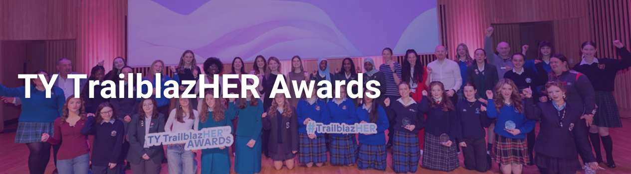 A group of young women pose with award presenters on a stage at the TrailblazHER TY Awards