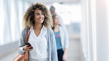 Image for Women holds a phone in her hand and looks out to her left.