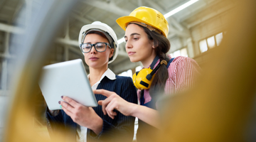 Image for White woman smiles at the camera. In white shirt and holding a pair of glasses in one hand with half crossed arms.
