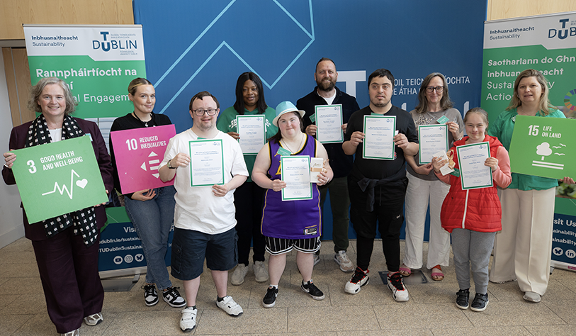 students and staff posed in two rows holding certificates