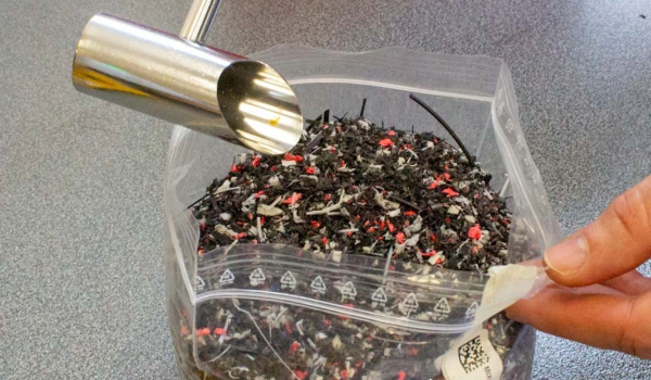 Machine shoot has deposited large quantity of shredded plastic waste into clear ziplock bag