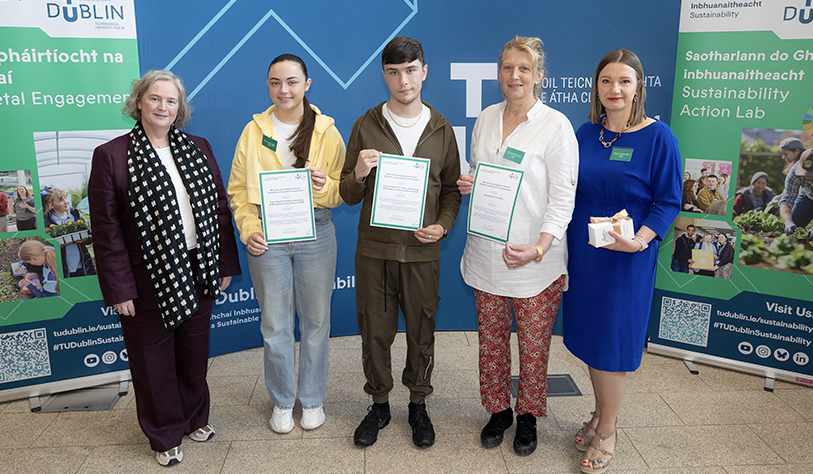 four white women and a younger male and female student posed in a row holding certificates