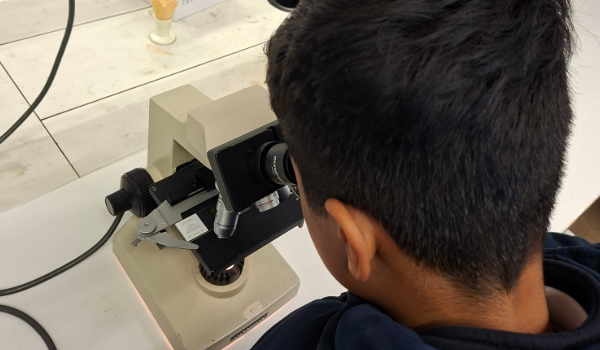 student looking at microscope