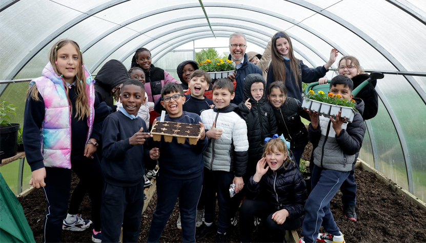 photo of Minister O'Gorman with school children in a poly tunnel at the GLAS at TU Dublin Community Garden