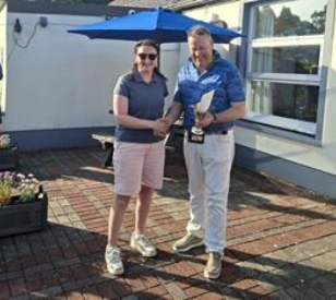 White woman and white man - woman receives award and shaking hands with man