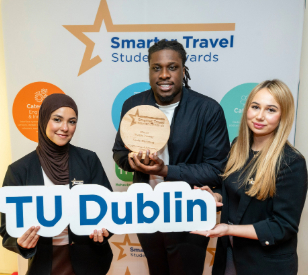 one asian woman, one black man one white women hold award and TU Dublin sign against backdrop of smarter travel student awards