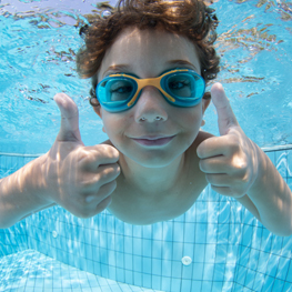 child in swimming pool wearing sports eyewear