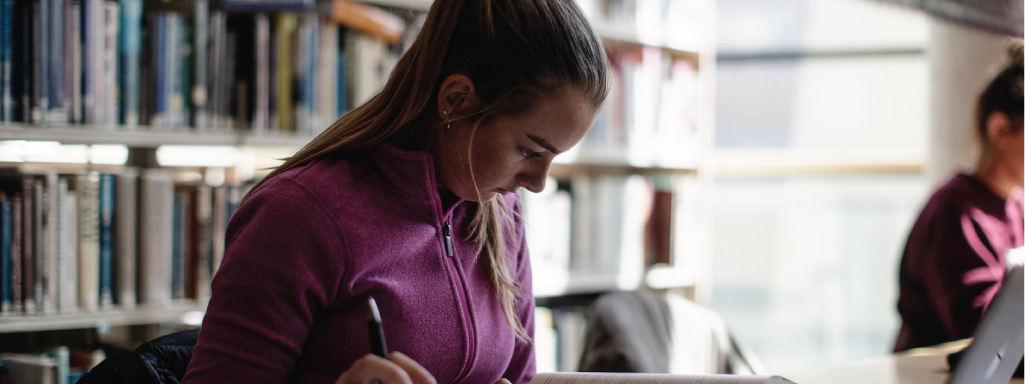 A student reading and using the laptop