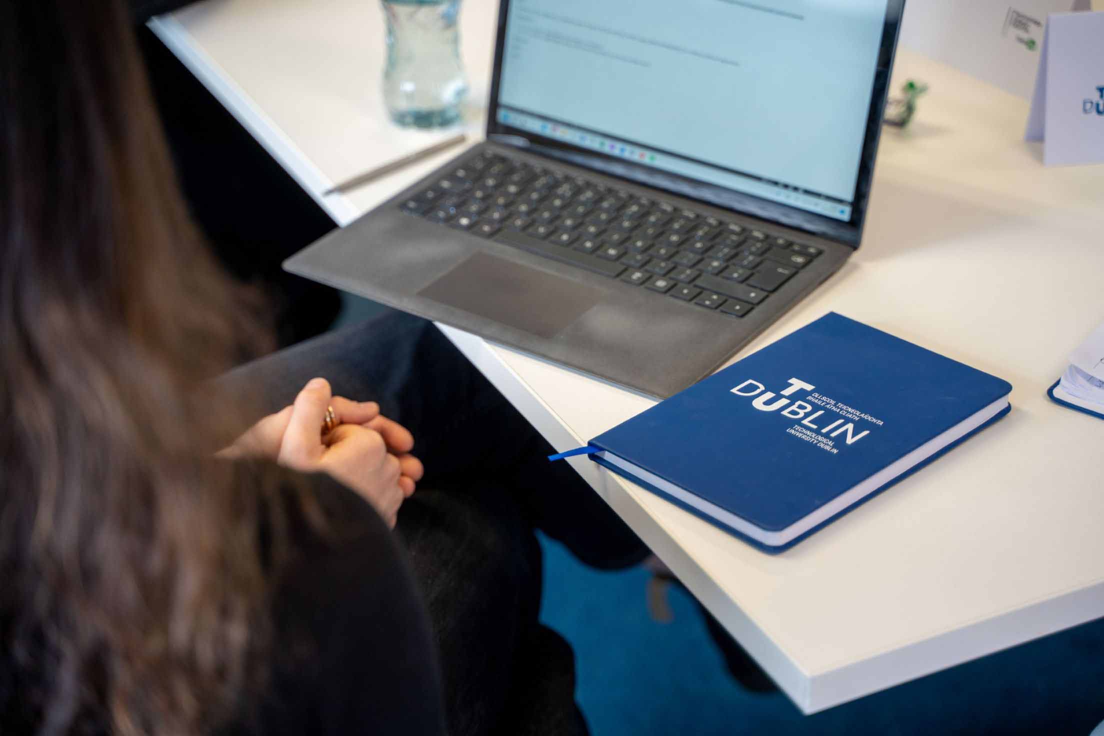 A student sitting with a laptop and diary on the desk.