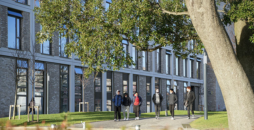 Photo of the School of Tourism & Hospitality Management with trees & plants in foreground