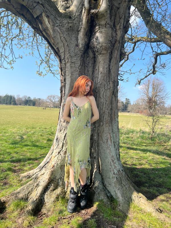 Student model standing against a tree