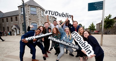 a group of people holding TU Dublin hashtag signs