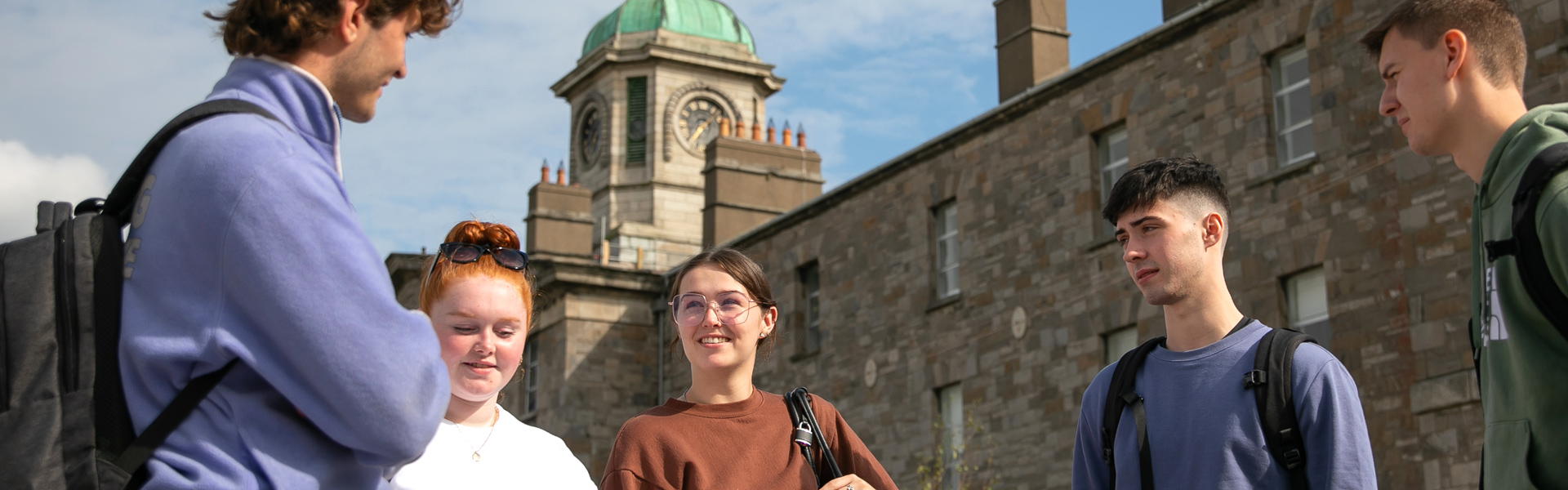 Students standing talking outside the clocktower on the Grangegorman campus