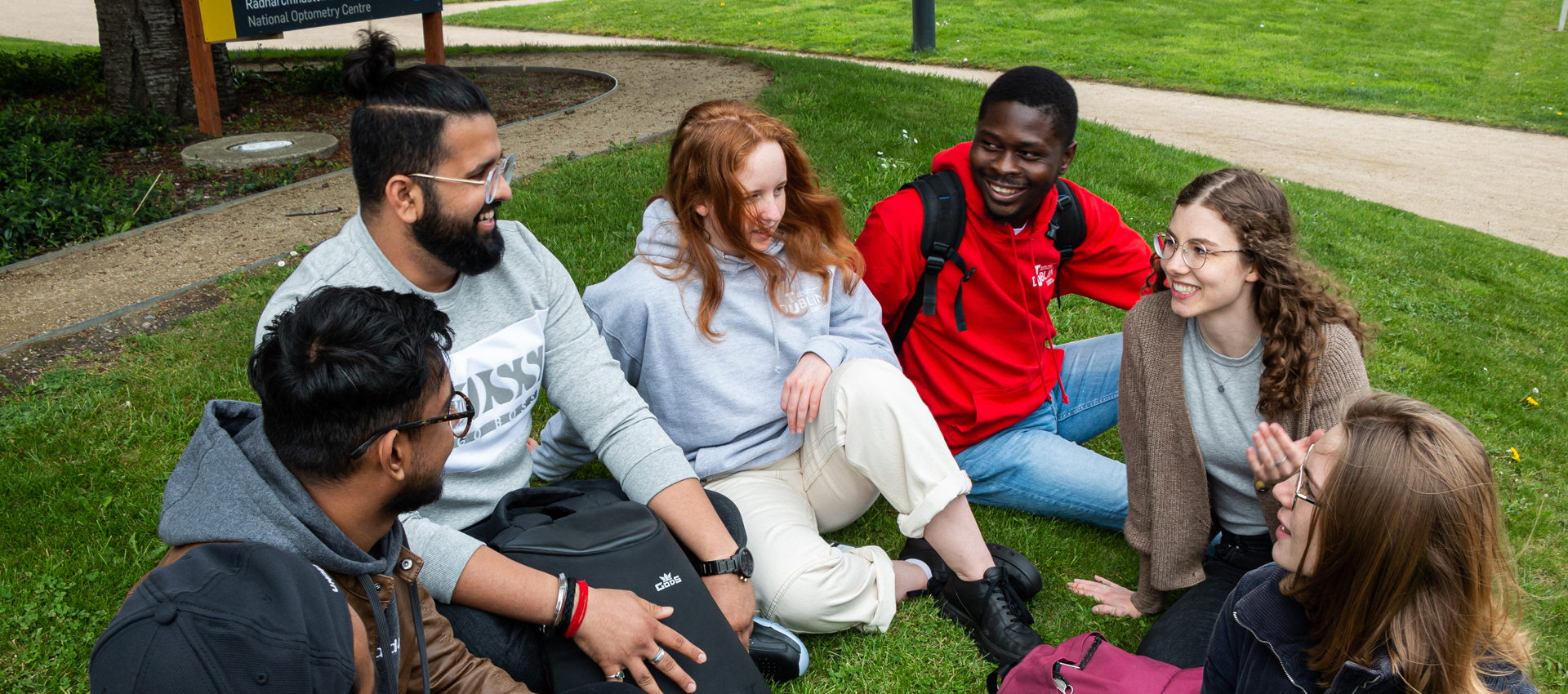 international students sitting on grass on grangegorman campus
