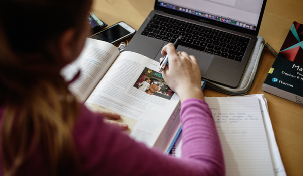 Student studying with laptop and book