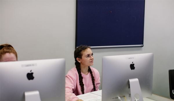 Student studying at a desk with screen