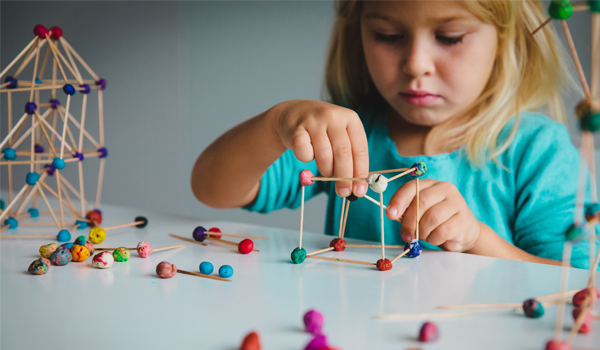 Child playing with play doh and sticks