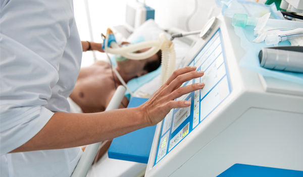 Healthcare worker operating a ventilator