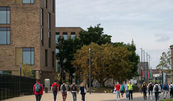 A photo of people walking into the Grangegorman Campus from the Luas Broadstone stop with the East Quad in the background