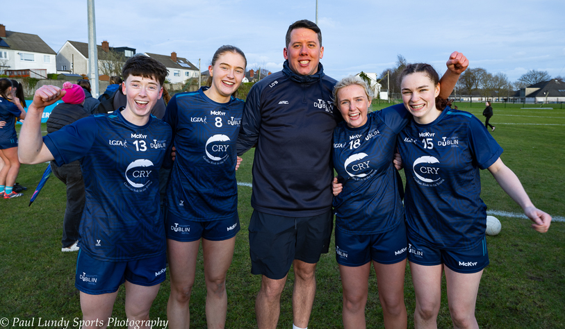 People in sporting clothing celebrate on a grass field