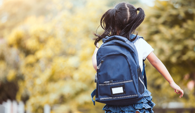 Child running with blue backpack