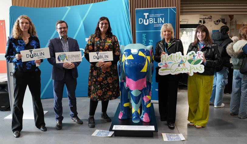 An image of a brightly coloured ceramic elephant with people posing beside it