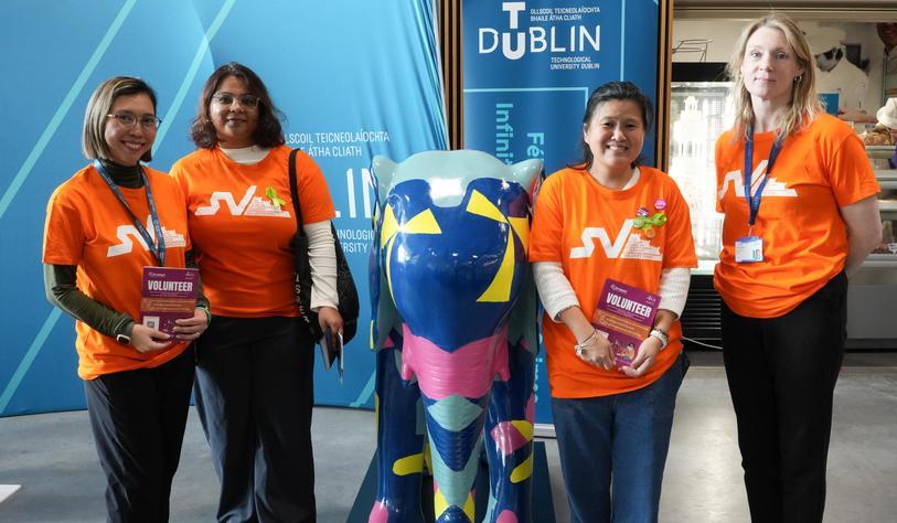 Student Volunteers and staff pose with a ceramic, brightly coloured elepant