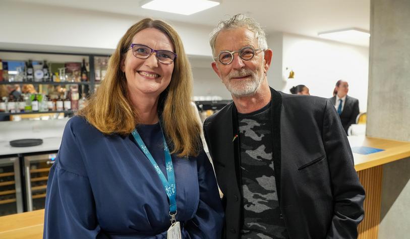 Two people smile for a photo