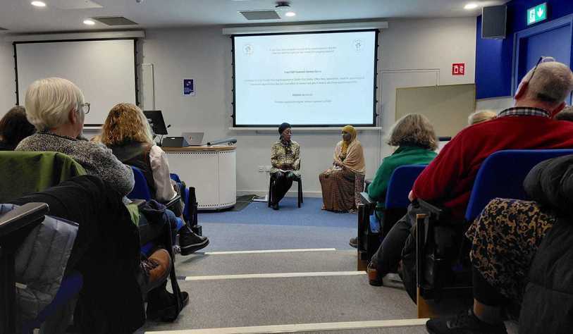 A panel of two people at the top of a lecture hall