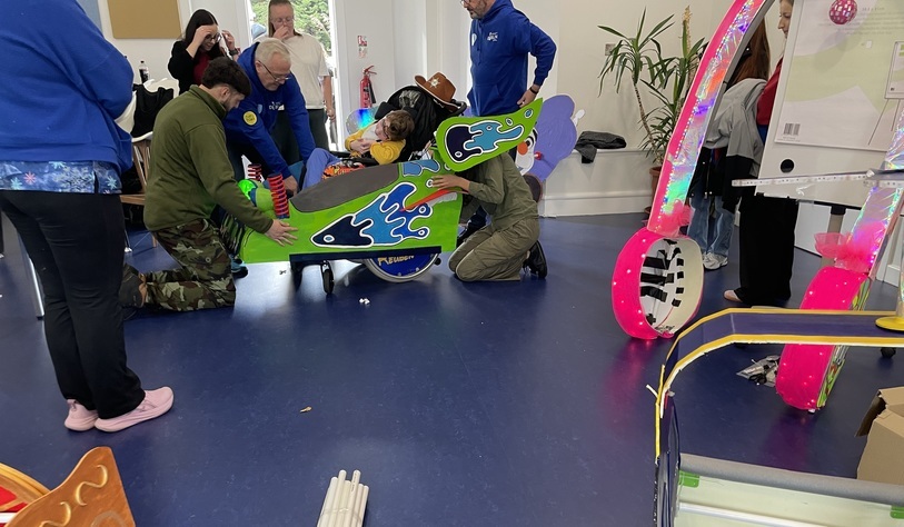 People working on the adaption of a wheelchair for a Halloween costume
