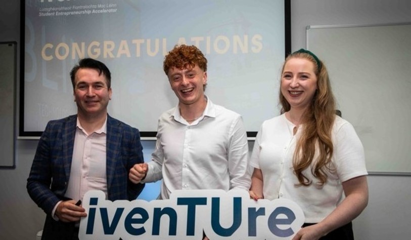 A group of people holding an Iventure sign and cheering