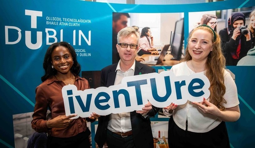 A group of people holding an Iventure sign and cheering