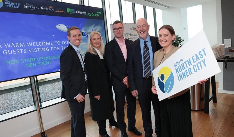 A group of people smiling with one person holding a cardboard cut out that says North East Inner City