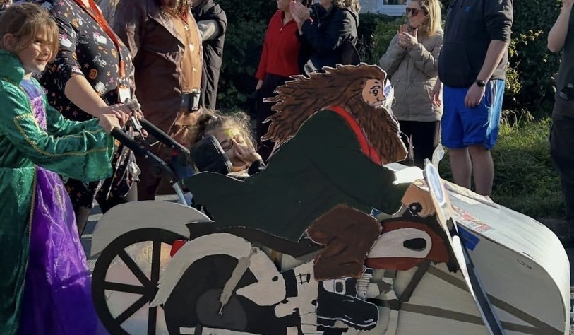 A group of participants showcase a creative homemade motorcycle and character-themed costume display.