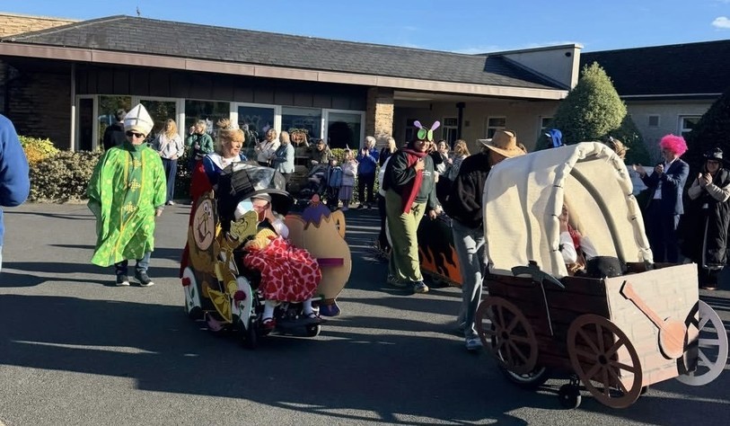 Participants in a variety of costumes, including a bishop, princesses and other colourful characters, take part in the parade with their decorated carriages.