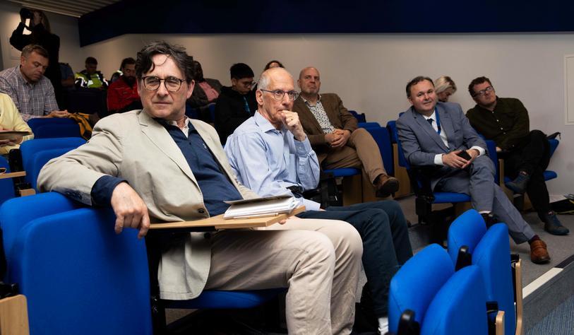 An audience in a tiered lecture hall