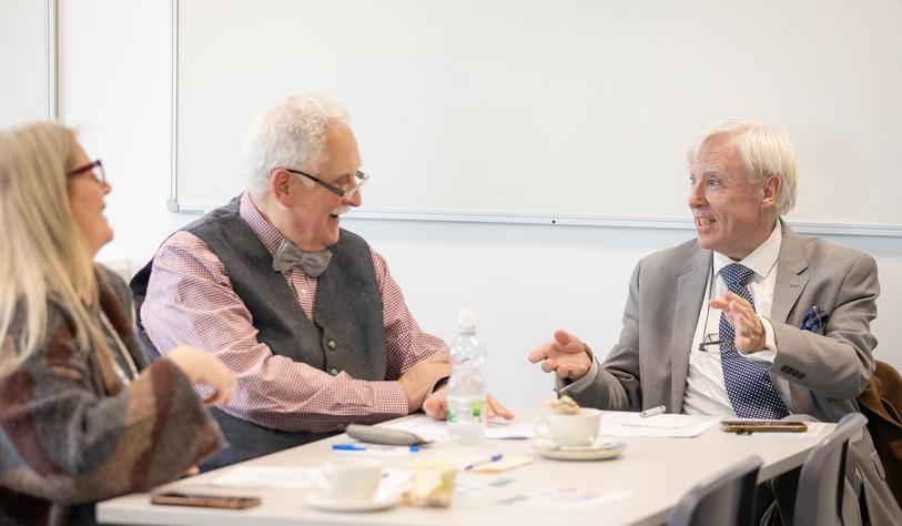 A group of people laughing and talking at an event