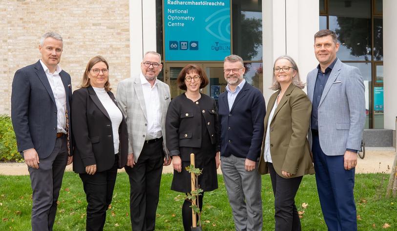 A group of people posing with a Sycamore Tree