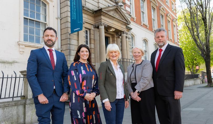 A group of people smile and pose for a photo