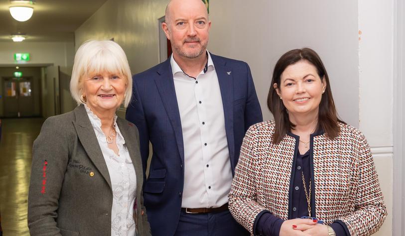 A group of people smile and pose for a photo