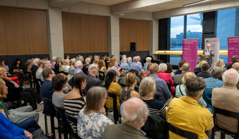 Attendees at an event listening to a speaker