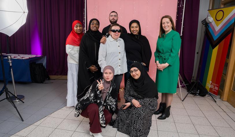 A group of people pose for a photo smiling and cheering