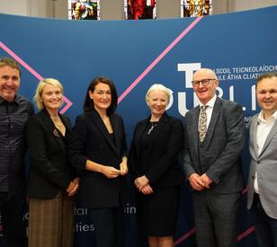 Group of six people standing together at TU Dublin’s Tallaght Campus, posing for a photograph in front of a TU Dublin branded backdrop.
