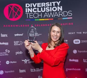 A person holds a trophy in front of a banner that says 2026 Diversity Inclusion Tech Awards.