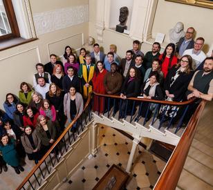 A group of people on a stairwell looking up to a camera