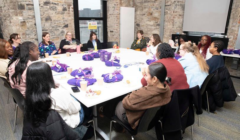 A group of people sit around a table and talk